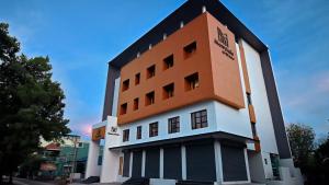 un edificio de color naranja y blanco en Hotel Merrytale, en Kurinjippādi