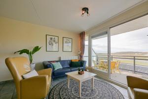 a living room with a couch and a table at Appartement Wijde Blick 207 - Callantsoog aan Zee in Callantsoog