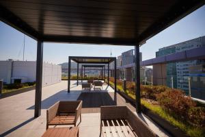 a patio with benches and tables on a building at Stay C Hotel Myeongdong in Seoul