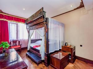 een slaapkamer met een hemelbed en een glazen tafel bij ChengDu Wuhou Temple Han Dynasty Hotel in Chengdu