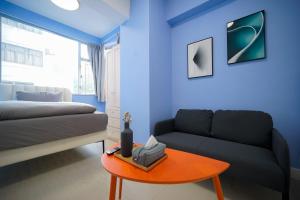 een blauwe woonkamer met een bank en een tafel bij Student Accommodation - 276 Gloucester Road in Hong Kong