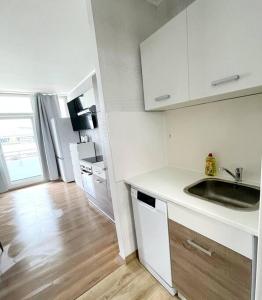 a kitchen with white cabinets and a wooden floor at Apartment in Neuss. 4 Personen in Neuss