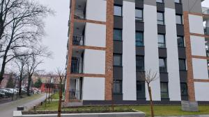 a tall building with a black and white facade at Apartament Temisto in Bydgoszcz