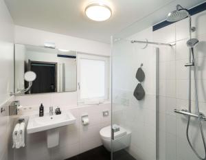 ein Bad mit einem Waschbecken, einem WC und einer Dusche in der Unterkunft ANA Living Karlsruhe by Arthotel ANA in Karlsruhe