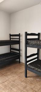 2 czarne łóżka piętrowe w pokoju w obiekcie BIMBA HOSTEL - UNIDADE 03 - GOIÂNIA - GO w mieście Goiânia