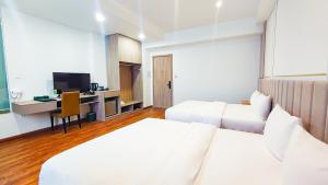 ein Hotelzimmer mit 2 Betten und einem Schreibtisch in der Unterkunft The Mansion Hotel Bien Hoa in Biên Hòa