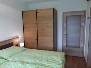a bedroom with a bed and a wooden cabinet at Apartment Kristall Real in Bad Radkersburg