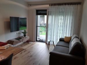 a living room with a couch and a large window at Apartment Kristall Real in Bad Radkersburg