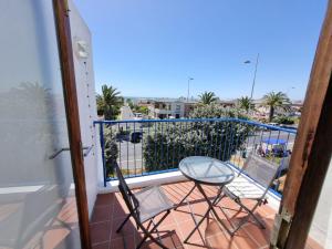 a balcony with two chairs and a table at 24 Arniston Village, Melkbosstrand in Melkbosstrand