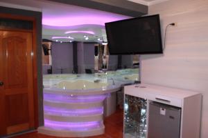 a bathroom with a tub with a tv on the wall at Hotel Venecia in Huánuco