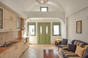 a kitchen with green doors and a living room at Ayoba Santorini in Imerovigli