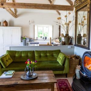 a living room with a green couch and a table at Seaves Mill Cartsheds in York