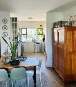 a kitchen and dining room with a wooden table and chairs at 504 on Wilderness in Cape Town