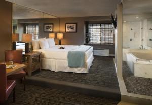 ein Hotelzimmer mit einem Bett und einer Badewanne in der Unterkunft Postmarc Hotel and Spa Suites in South Lake Tahoe