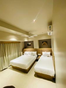 孟買的住宿－HOTEL AMBER PARAMOUNT，一间卧室设有两张床和窗户。