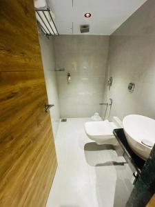 HOTEL AMBER PARAMOUNT في مومباي: حمام مع مرحاضين ومغسلة