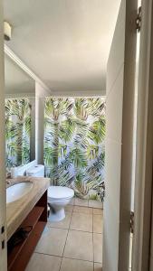 a bathroom with a white toilet and a tropical wallpaper at Dpto acogedor en Lastarria in Santiago +5 photos