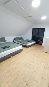 Habitación con 2 camas y suelo de madera. en SuperChata sk - Moderné ubytovanie pod Sninským kameňom, 