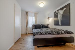 a bedroom with a bed and a large painting on the wall at Mama Home Apartment W26 in St. Gallen