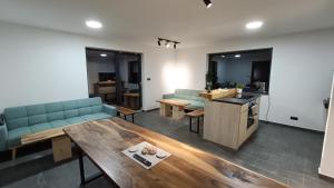 a living room with couches and a table and a kitchen at SuperChata sk - Moderné ubytovanie pod Sninským kameňom in Hámry
