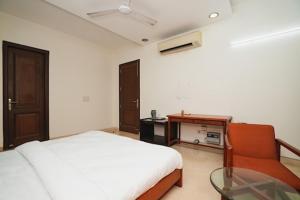 a bedroom with a bed and a glass table at Greenleaf Apartment and Suites, Kalkaji in New Delhi