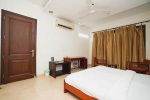 a bedroom with a bed and a wooden door at Greenleaf Apartment and Suites, Kalkaji in New Delhi