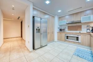 a kitchen with a stainless steel refrigerator at Direct Access to Nakheel Mall At the Heart of The Palm in Dubai
