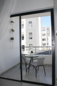a patio with a table and chairs on a balcony at Nid de Rêve Accommodation in Midrand