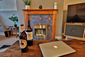 a table with two bottles of wine and a laptop at ZSKstays! Comfortable home, 10 minutes from centre, free parking! in Hull