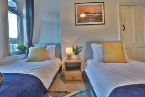 1 dormitorio con 2 camas y mesa con lámpara en ZSKstays! Comfortable home, 10 minutes from centre, free parking! en Hull
