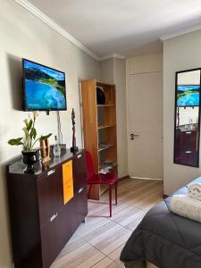 a bedroom with a dresser with a television on top of it at Dpto acogedor en Lastarria in Santiago