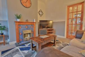 uma sala de estar com lareira e televisão em ZSKstays! Comfortable home, 10 minutes from centre, free parking! em Hull