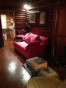 un sofá rojo sentado en una habitación con libros en Haut vue Cervin Matterhorn, en Antey-Saint-André