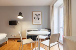 a living room with a table and chairs at easyhomes - Spiga Suite in Milan