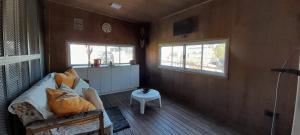 a room with a couch and two windows and a table at Hostal del Sol Rosario in Rosario