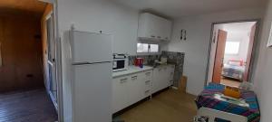 a kitchen with white cabinets and a white refrigerator at Hostal del Sol Rosario in Rosario +6 photos