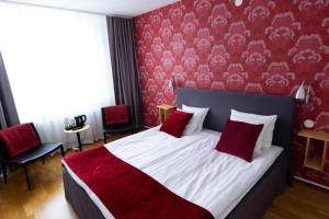 a bedroom with a large bed with red walls at City Central Hotel Örebro by First Hotels in Örebro
