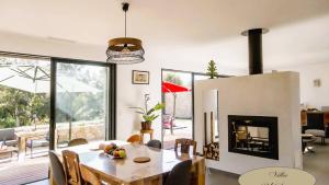 comedor con mesa y chimenea en Villa U Scopu, 6 pers, piscine chauffée, 10 mn plage en voiture, en Lecci