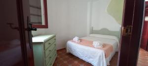 una piccola camera con un piccolo letto e un comò di Casa Pilar Seco a Láujar de Andarax