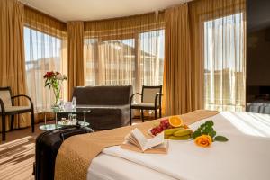 a hotel room with a bed with a book and fruit on it at Europe Hotel in Sofia