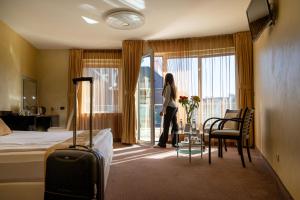 Eine Frau steht in einem Hotelzimmer mit Blick aus dem Fenster in der Unterkunft Europe Hotel in Sofia