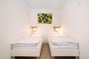 two beds in a room with a painting on the wall at Haus Loser in Wasserburg