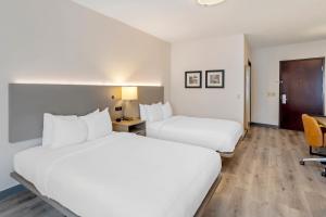 a hotel room with two beds and a desk at Comfort Inn & Suites Sayre in Sayre