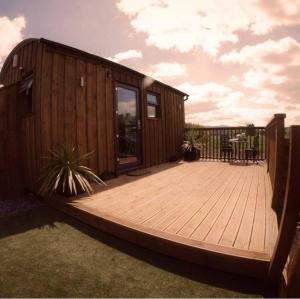 a wooden deck with a house with a table at The Ginger Nut in Welshpool