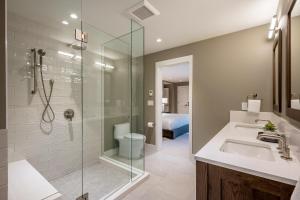 a bathroom with a sink and a glass shower at Glacier View Chalet - Tranquil Chalet with Private Hot Tub & Golf Course Views - Whistler Platinum in Whistler