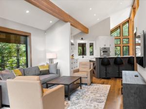 a living room with a couch and a table at Glacier View Chalet - Tranquil Chalet with Private Hot Tub & Golf Course Views - Whistler Platinum in Whistler