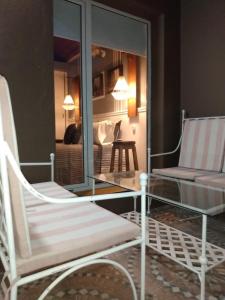 a living room with two chairs and a glass table at CASA NELLY by ABORIGEN APARTAMENTOS BOUTIQUE in Puerto Madryn