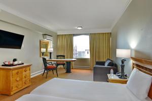 una camera d'albergo con letto, divano e tavolo di The Capetonian - Halaal a Città del Capo