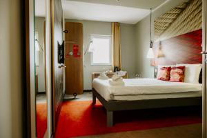 a bedroom with a large bed and a mirror at Ibis Sofia Airport Hotel in Sofia
