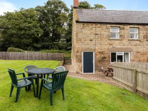 a table and chairs in the yard of a cottage at Bilton Farm Cottage No1 in Alnmouth